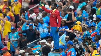 Bild: Fernando Llano/AP/dpa
Kongos Fan Michel Nkuka Mboladinga zieht beim WM-Spiel die Blicke auf sich.