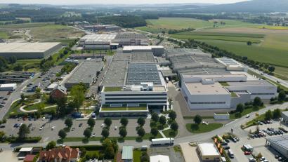 Bild: Siemens Healthineers
Der Siemens-Healthineers-Standort Kemnath erhält eine neue Fertigungshalle. In das Bild ist das rund 4500 Quadratmeter große Gebäude vorne rechts als Grafik eingefügt.