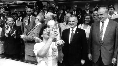 Bild: dpa/Picture-Alliance/dpa
29.6.1986: Der argentinische Fußballstar Diego Maradona jubelt mit dem eroberten Weltmeisterschaftspokal - der mexikanische Staatspräsident Miguel de la Madrid (2. von rechts) und Bundeskanzler Helmut Kohl (rechts) schauen zu. (Archivbild)