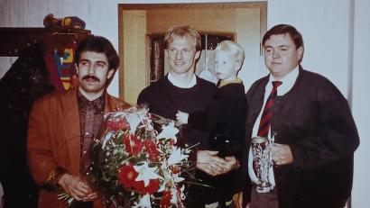 Archivbild: Johann Heibl
Ein Jahr, nachdem er mit der deutschen Mannschaft Weltmeister geworden war, kam Hansi Pflügler 1991 mit Sohn im Arm zu einer Autogrammstunde ins Clublokal Rast nach Weiherhammer. Links Max Artmann, rechts Clubchef Hans Heibl.