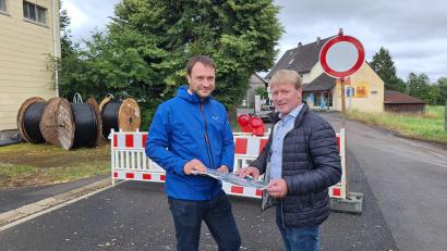 Bild: bl
Verwaltungsleiter Thomas Prey (links) und Bürgermeister Markus Schiesl haben den Überblick über die komplexe Baustelle in Altendorf. Links liegen bereits die neuen Stromkabel bereit, das Trafohäuschen wird abgebaut.