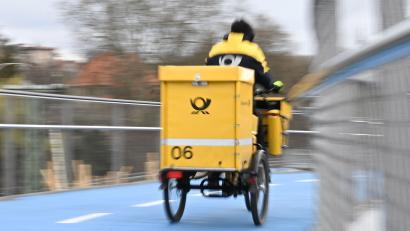Bild: Bernd Weißbrod/dpa
Ein Postbote bei der Arbeit: Wie lange waren seine Briefe wohl unterwegs?