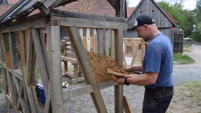 Bild: Richard Braun
Ein Museumshandwerker zeigt die fachgerechte Ausführung einer Lehmausfachung.