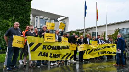 Bild: Jens Kalaene/dpa
Vertreter mehrerer Städte und Kommunen demonstrieren mit Schildern und Bannern für finanzielle Unterstützung in Berlin.