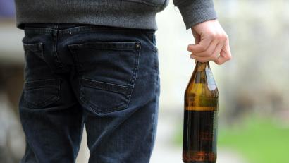 Symbolbild: Tobias Hase /dpa
Eine Person hält eine geöffnete Bierflasche in der Hand. In Regensburg hat ein 29-Jähriger mit einer geworfenen Flasche eine Frau im Gesicht verletzt.
