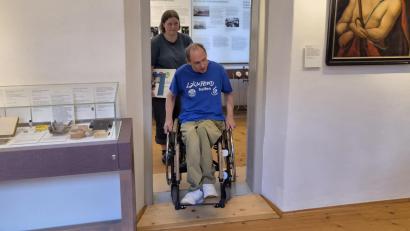 Bild: lue
Matthias Plonner, stellvertretender Behindertenbeauftragter der Marktgemeinde Konnersreuth, fährt über eine Rampe, um im Theres-Neumann-Museum von einem Raum in den anderen zu kommen. Auch die Türöffnungen wurden verbreitert, um ein einfacheres Durchkommen zu ermöglichen.