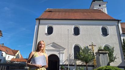 Bild: bl
Marie Kick setzt sich dafür ein, dass der Storch einen sicheren Platz auf der Stadtpfarrkirche in Pfreimd bekommt und hat dazu eine Unterschriftenaktion gestartet. Oben auf dem Dach sieht man noch die Reste des Nestbau-Versuchs, die Zweige sind bis zum Schneefanggitter abgerutscht.