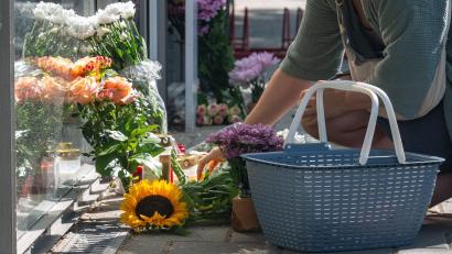 Bild: Armin Weigel/dpa
Eine Frau legt eine Karte zu Blumen und Kerzen, die vor der Bankfiliale abgelegt wurden. Nach der tödlichen Messerattacke in einer Regensburger Bank versucht die Kriminalpolizei weiter, die Hintergründe aufzuklären.