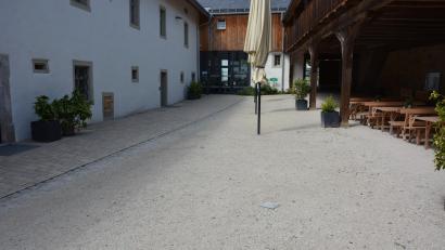 Bild: Josef Rosner
Links der befestigte Zugang zum Museum im Hintergrund, rechts der Sandboden, der nach Meinung von Reinhard Wurm ebenfalls befestigt werden sollte: Sand wird oft in die Räumlichkeiten getragen. Der Bürgermeister sucht dazu das Gespräch mit der Denkmalschutzbehörde.