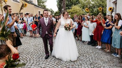 Bild: easyandflow
Das Brautpaar Christian Mösbauer und Doris Drexler inmitten der Gratulanten vor der Hiltersrieder Kirche.