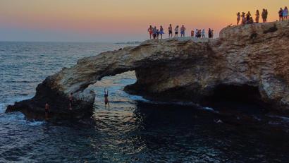 Bild: Petros Karadjias/AP/dpa
Ein junger Mann springt bei Sonnenuntergang im Ferienort Ayia Napa auf der im östlichen Mittelmeer gelegenen Insel Zypern von der natürlichen "Liebesbrücke" ins Meer.