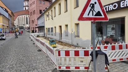 Bild: Tobias Gräf
Auf Höhe von Elektro Erras und auf der anderen Seite vor dem Genussladen Ottmann wird der Gehweg saniert. Fußgänger müssen teils auf die Straße ausweichen.