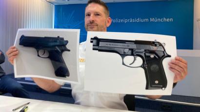 Bild: Sabine Dobel/dpa
Polizeisprecher Thomas Schelshorn zeigt Fotos der Softair-Waffe und der echten Waffe.