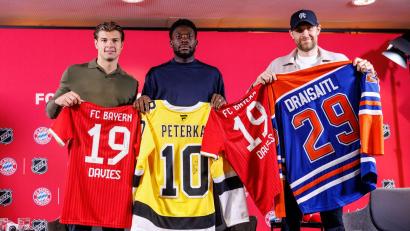 Bild: Matthias Balk/dpa
Fußball und Eishockey als Partner: Die deutschen Eishockeystars John-Jason Peterka (l) und Leon Draisaitl (r) mit dem kanadischen Bayern-Profi Alphonso Davies.