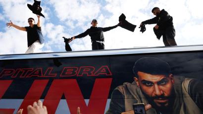 Bild: Carsten Koall/dpa
Die Rapper Lacazette, Capital Bra und Samra werfen bei einer Fanaktion in Kreuzberg T-Shirts von einem Tourbus.