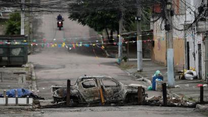 Bild: Bruna Prado/AP/dpa
Ein ausgebranntes Auto versperrt eine Straße in der Favela „Complexo de Israel“, nahe weiterer Favelas, in denen die Polizei derzeit Razzien gegen Drogenbanden durchführt.