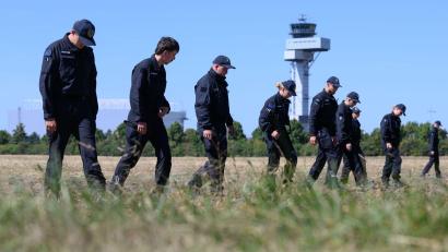 Bild: Hendrik Schmidt/dpa
Einsatzkräfte durchkämmten nach der Entdeckung der Drohne die Umgebung des Flughafens. (Archivbild)