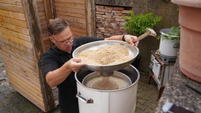 Bild: fvo
Mit Hilfe des sogenannten Doms füllt Michael Troidl das Malz in das Innenrohr des Brautopfs ein.