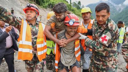 Bild: Uncredited/Nepal Army/AP/dpa
Ein geretteter Mann wird von Bergungskräften getragen.