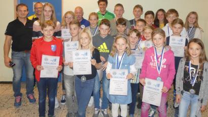Bild: Heiko Schneider
Die erfolgreichen Sportler bei der Siegerehrung des Kids-Cups 2018 in Kümmersbruck mit den Jugendleitern des BTV-Bezirks Oberpfalz, Harald Kaunz (links) und Christian Betzlbacher (rechts daneben), dem Vorsitzenden des BTV-Bezirks Oberpfalz, Gerd Rucker (hinten, Fünfter von links), und Profi-Triathlet Sebastian Neef (rechts daneben).