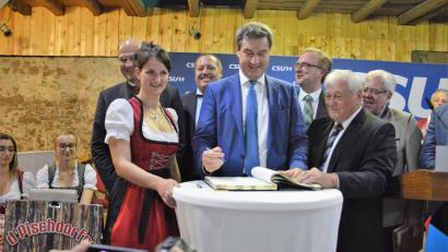 Bild: mp
Beim CSU-Sommerempfang in Guteneck trägt sich Ministerpräsident Markus Söder ins Goldene Buch der Gemeinde ein.