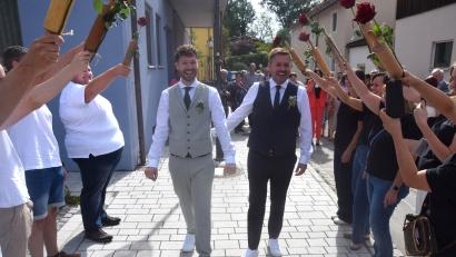 Bild: Ernst Frischholz
Mit einem lachenden Gesicht schreiten Alexander Köhle (rechts) und Josef Irlbacher (links) nach der Trauung durch das Rosenspalier der Kolleginnen und Kollegen der Bäckerei Meier in Etzgersrieth.