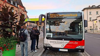 Bild: Jürgen Lenkeit
Schienenersatzverkehr in Richtung Kirchenlaibach am Bahnhofsvorplatz in Marktredwitz – am Gehsteig wartet der Fahrkartenkontrolleur.
