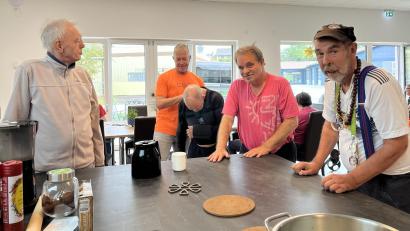 Bild: Dr. Loew Soziale Dienstleistungen
Bei der Betreuung von Menschen mit körperlichen und psychischen Behinderungen hat Biwi Hüther (im orangen Shirt) mit 60 einen neuen Platz in der Arbeitswelt gefunden. Hier hilft er in einer Wohngruppe in Wernberg einem verletzten Bewohner beim Justieren seines Schultergurts.