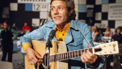 Archivbild: dpa
Michael Thilo, deutscher Sänger und Songschreiber, bei einem Fernsehauftritt im Jahr 1975. Der Sänger erreichte durch ein Lied für die Hörspielreihe zu „Benjamin Blümchen“ viele junge Zuhörer. Jetzt wurde bekannt, dass er im März 2026 gestorben ist.