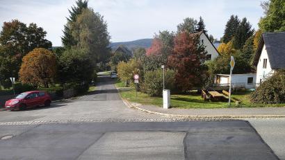 Bild: Bertram Nold
Diese zum schnellen Einfahren verführerische "Trompete" wird verschwinden und ganz neu gestaltet. Der Bruckweg wird 4,30 Meter breit. Noch in diesem Jahr soll Baubeginn sein. Der Vorplatz am Basshaus soll noch geräumt, Humus undSträuchersollen entfernt werden. Der Asphalt im Bruckweg bleibt über den Winter noch erhalten.