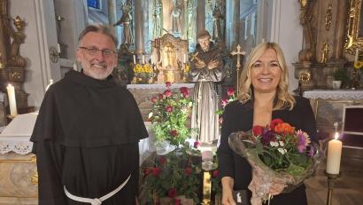 Bild: Martin Staffe
Vor der mit 44 roten Rosen geschmückten Franziskusstatue dankt Guardian Pater Stanislaus Sängerin Heidi Reil für ihre einfühlsamen Lieder.