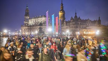 Bild: Robert Michael/dpa
Teilnehmer des Spazierclubs laufen am Abend durch Dresden.
