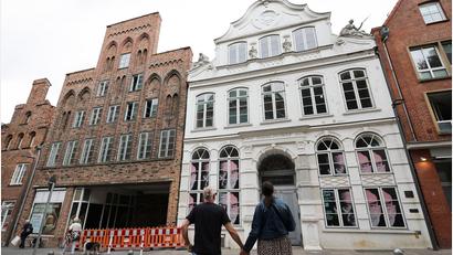 Bild: Christian Charisius/dpa
Passanten betrachten das geschlossene Buddenbrookhaus in der Lübecker Altstadt.