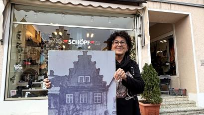 Bild: Holger Stiegler
Ulrike Scherm vor ihrem Schuhfachgeschäft in Kemnath: Das historische Foto dokumentiert, wie es Mitte der 1920er-Jahre ausgesehen hatte, kurz bevor ihre Großeltern das Haus gekauft hatten.