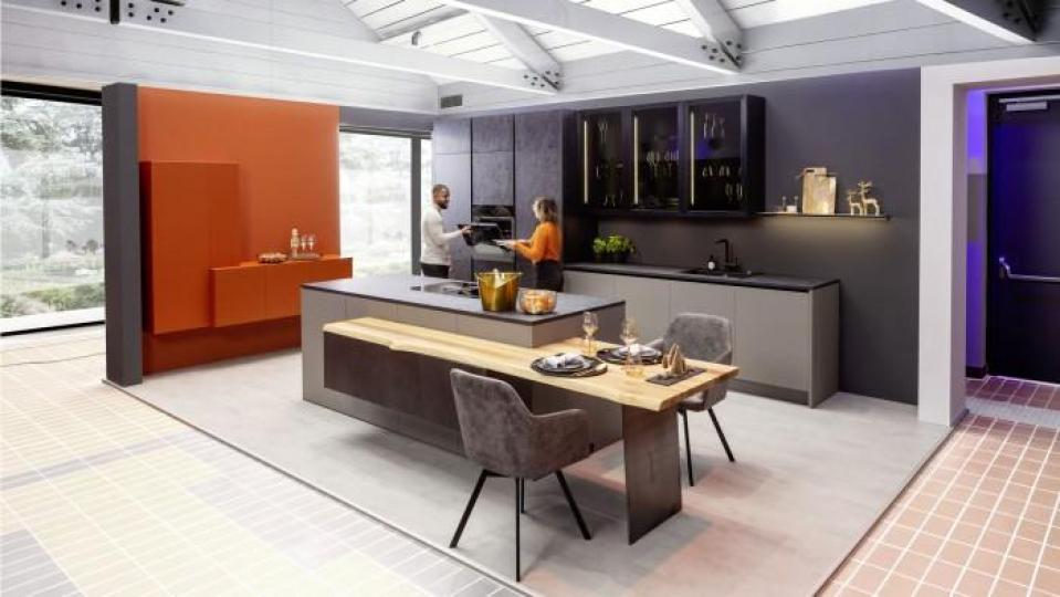 Eine moderne Einbauküche in dunkler Optik mit Ansetztisch. Bild: exb