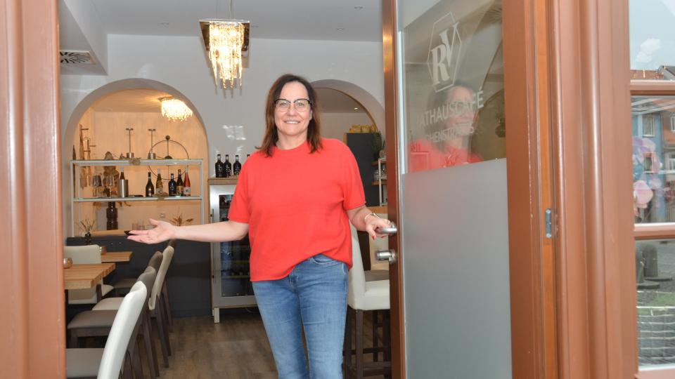 Die neue Pächterin des Rathaus-Café, Ilona Forster, öffnet ihre Pforten mit einer einladenden Geste. Bild: dob