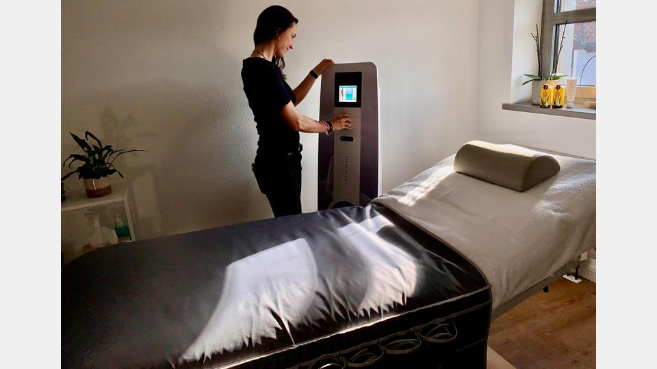 Sandra Götz mit den DiViNiA® Eco-Gerät für die Body-Behandlungen. Bild: mia