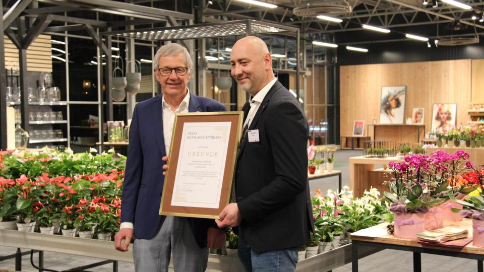 Hermann Berchtenbreiter (links), der Präsident des Bayerischen Gärtnereiverbandes, überreichte Reinhard Steinhilber (rechts) eine Dankurkunde des Verbandes für seinen unternehmerischen Mut. Foto: Hans Prem