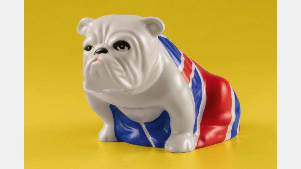 Figur „Jack the Bulldog“, Royal Doulton, Stoke-on-Trent: Einer der berühmtesten Geheimagenten der Welt ist James Bond. Seit 2012 begleitet ihn die Porzellanfigur „Jack the Bulldog“. Als stummer Beobachter im Büro von M steht der kleine Hund mit Union-Jack-Flagge sinnbildlich für britische Loyalität und Zähigkeit. Bild: Porzellanikon, Andreas Gießler