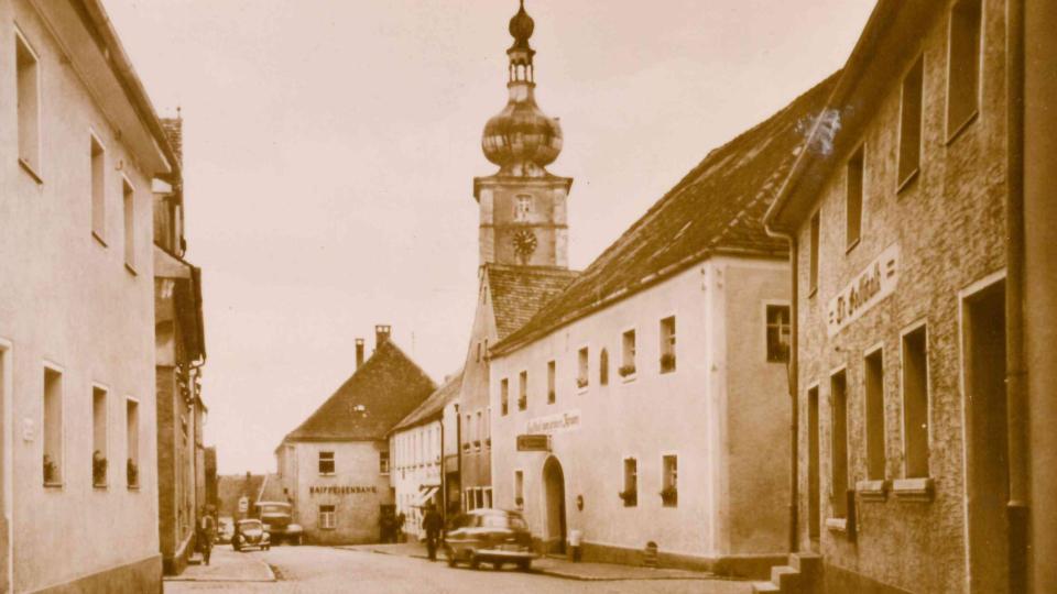 Zwischen der einstigen Raiffeisenbank (im Hintergrund) und dem "Grünen Kranz" (rechts zweites Haus von vorn) stand einst das Hautmannhaus, erstes Domizil der Werkstatt. Bild: Dr. Bernhard Piegsa